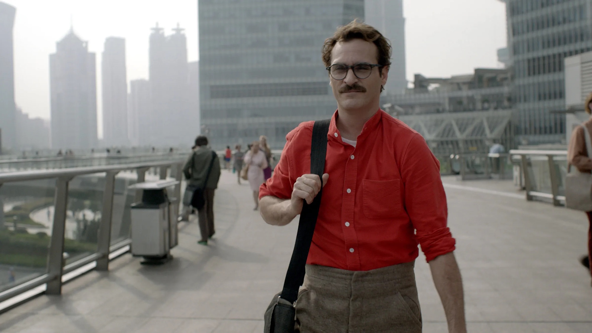 Theodore walking across a city bridge among other commuters