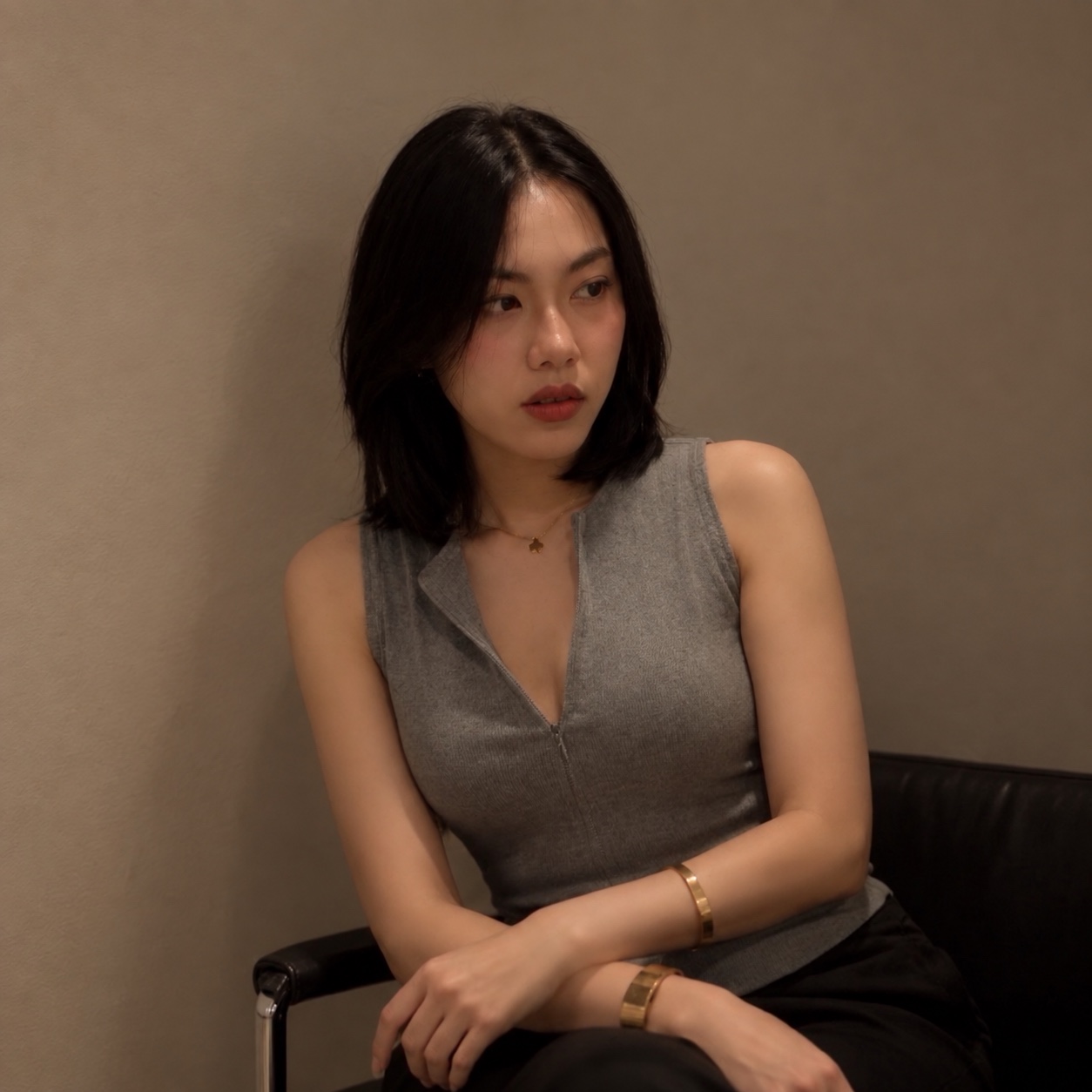 Portrait of Sirin seated against a warm brown wall